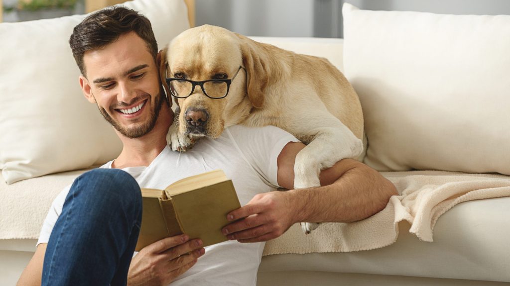 Man and dog reading a book together