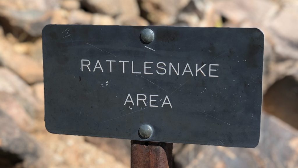 sign that reads "rattlesnake area"