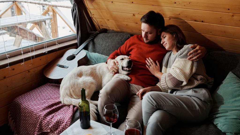 couple in cabin on couch with golden retriever