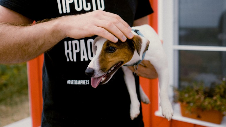 man holding terrier petting the dog's head