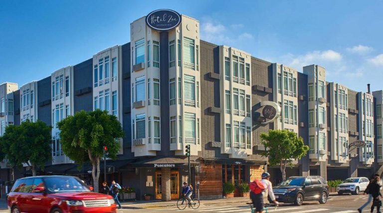 Hotel Zoe, a three-story, pet-friendly hotel with large windows near Fisherman's Wharf, sits beside shops and busy sidewalks.