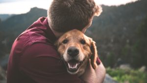 Fuzzy Pet Care man hugging dog