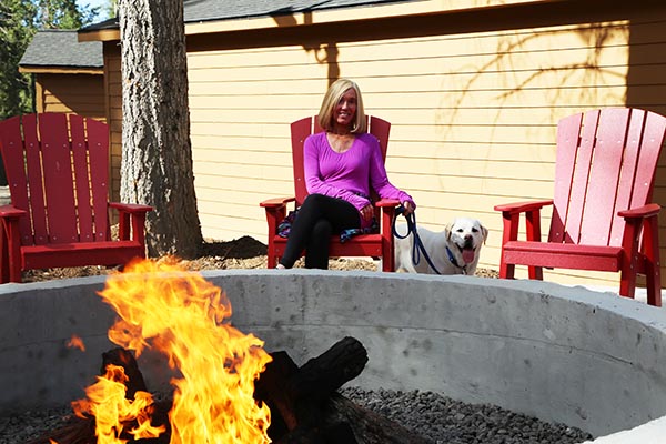 woman and dog by firepit