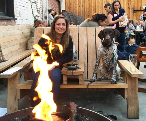 Dog and person in front of firepit in Oakland