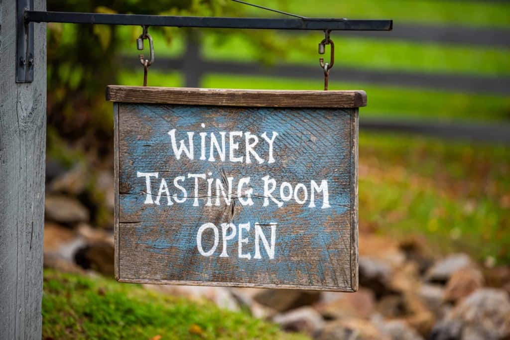 hanging sign that reads "winery tasting room open"