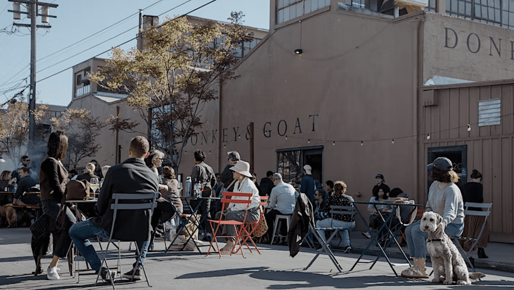 people sit at tables and chairs in the street