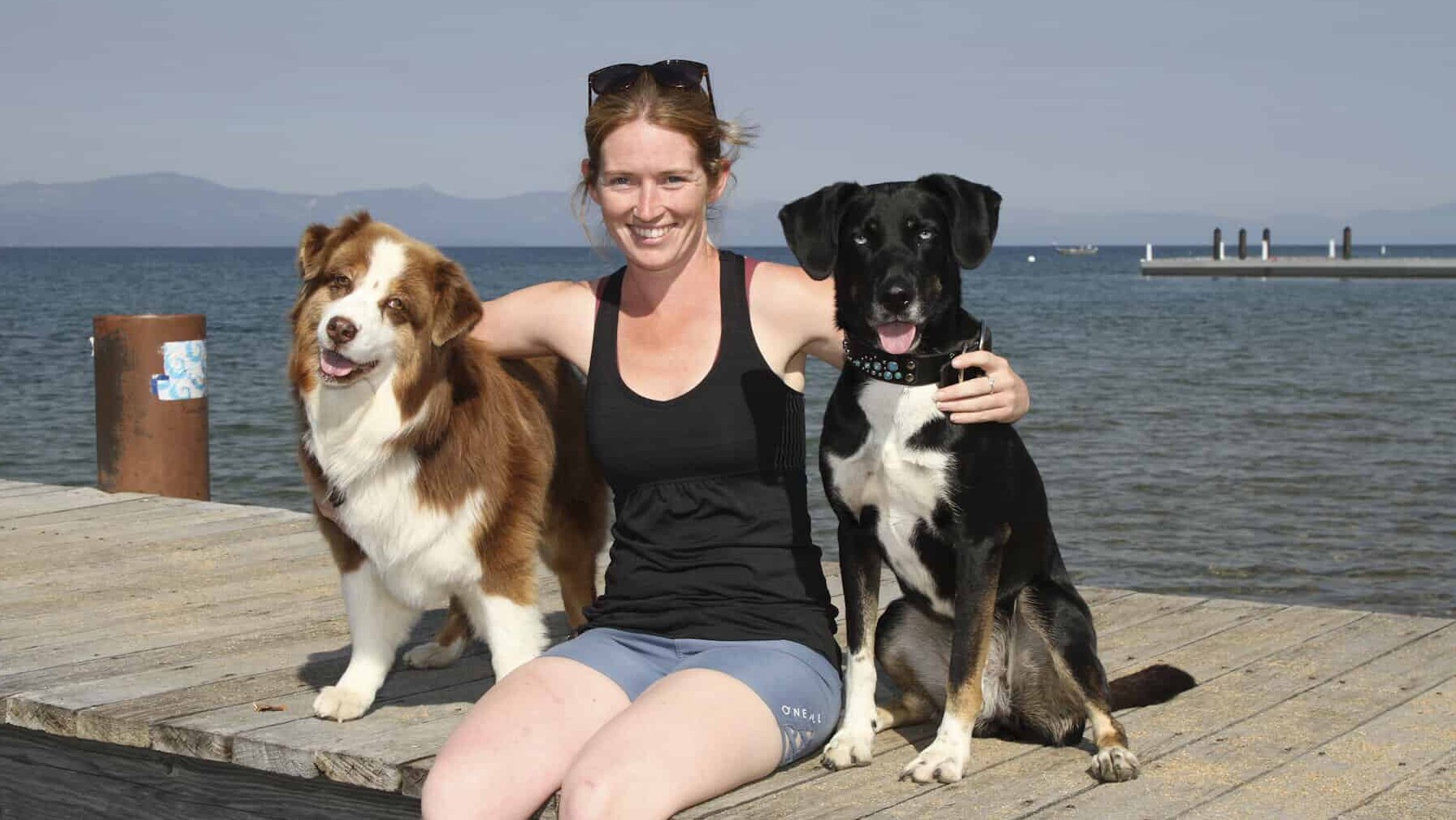 Woman on dock with two dogs at Tahoe