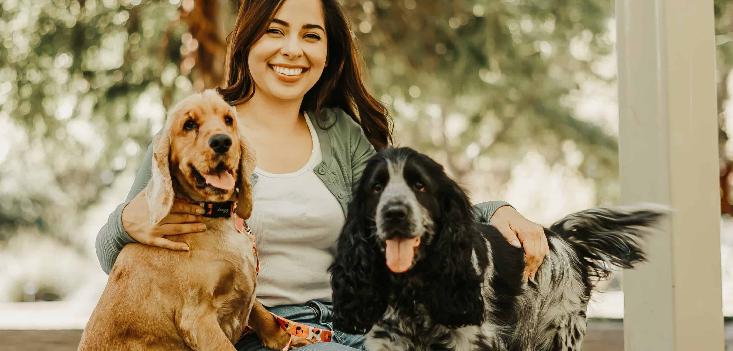 woman sitting with 2 dogs