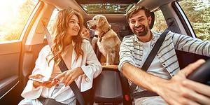 Mom,Dad,daughter-traveling-with-ipad-in-car-with-dog