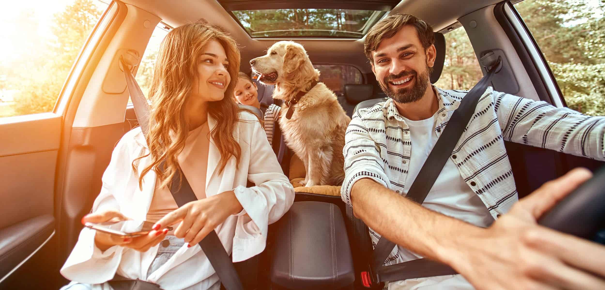 Mom,Dad,daughter-traveling-with-ipad-in-car-with-dog
