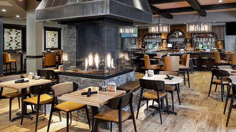 a restaurant with tables and chairs and a fire place.