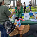 A costume-clad dog with a woman at the DogTrekker booth at Dogfest Bay Area.