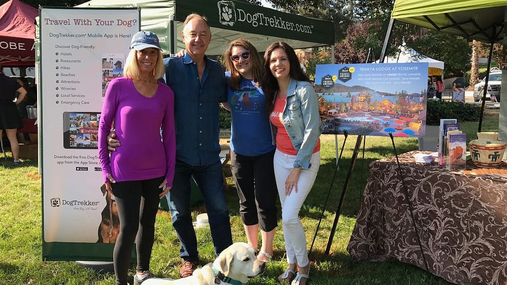 People and a dog in front of the DogTrekker booth at Bark in the Park, San Jose.