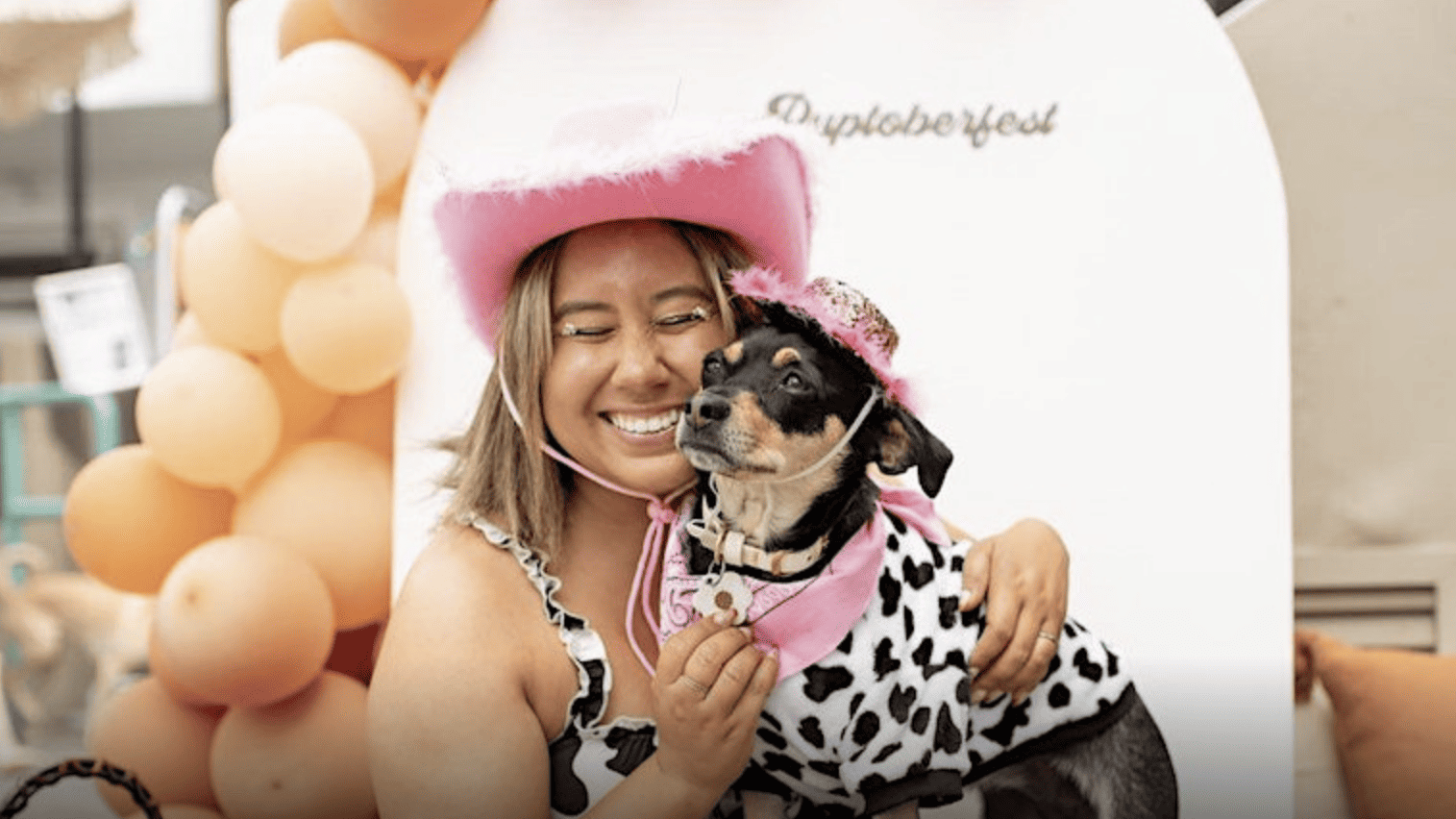 Woman and dog wearing pink cowboy hats
