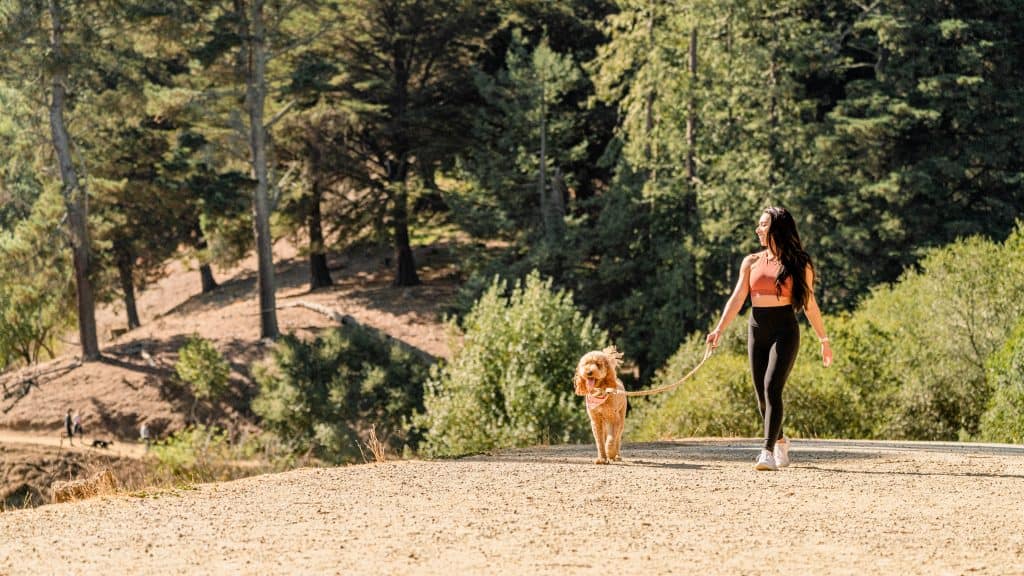 woman hiking with dog at Joaquin Miller Park in Oakland.