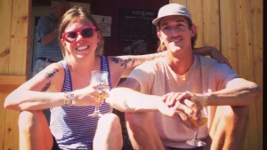 The New Museum proprietors sitting on a step with a beer