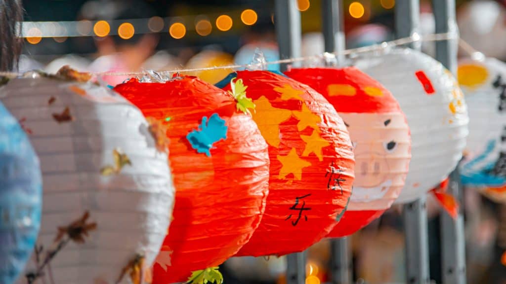 A line of lanterns hanging from a pole at the Lantern Paw Festival. - Dogtrekker