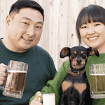 Couple holding dog and beer