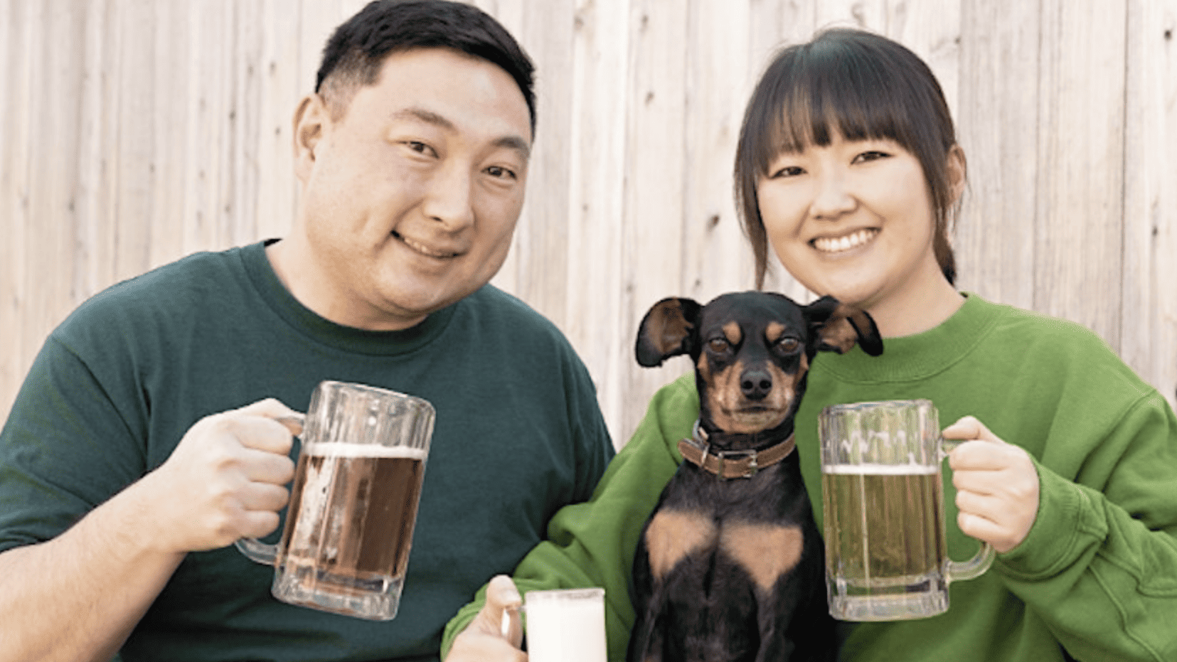 Couple holding dog and beer