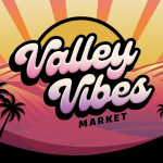 The "Valley Vibes Market" sign, shown in retro cursive font, stands out against a backdrop of a sunset over rolling hills. The sky glows with pink, yellow, and orange hues, detailed with sun rays stretching outward. Silhouetted palm trees in the foreground complete the scene, evoking a lively and nostalgic atmosphere.