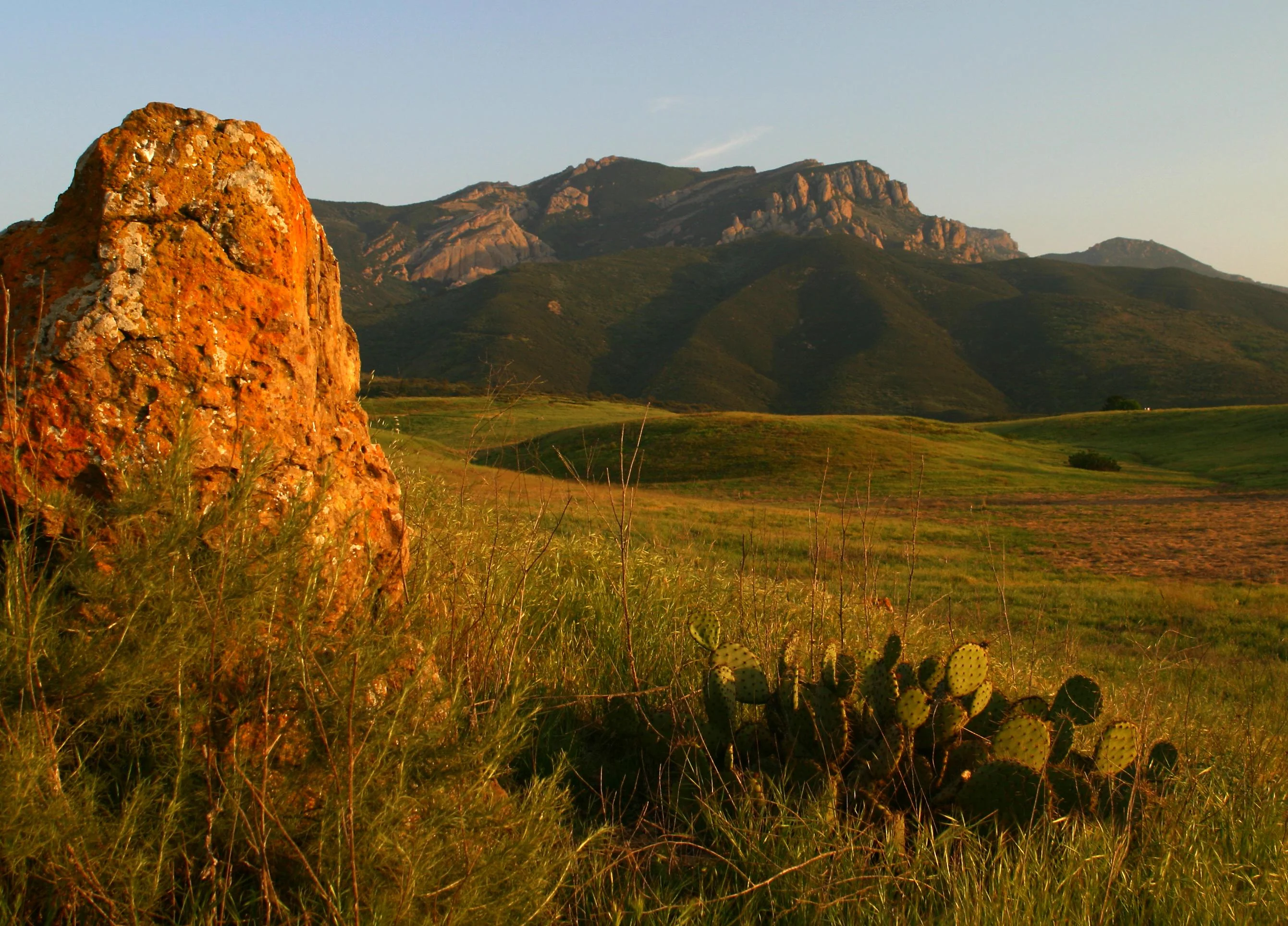 Boney Mountain at sunset with rock and cactus in foreground.