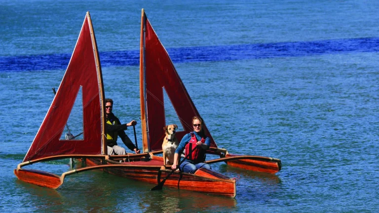 Dog and people on outrigger canoe.